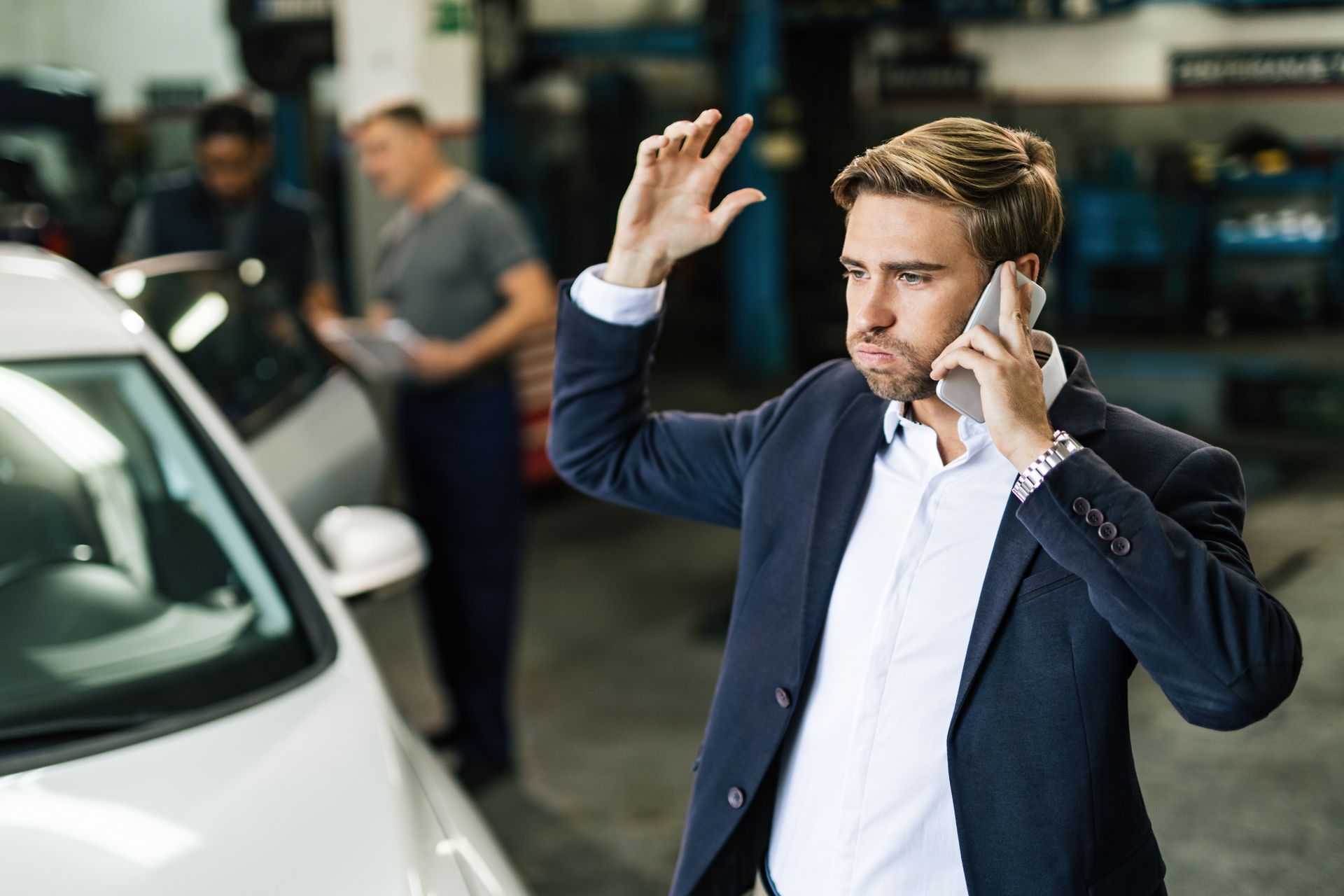 Man having an argument on mobile phone by car