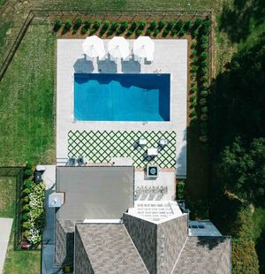 An aerial view of a house with a large swimming pool