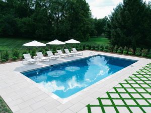 A large swimming pool surrounded by chairs and umbrellas