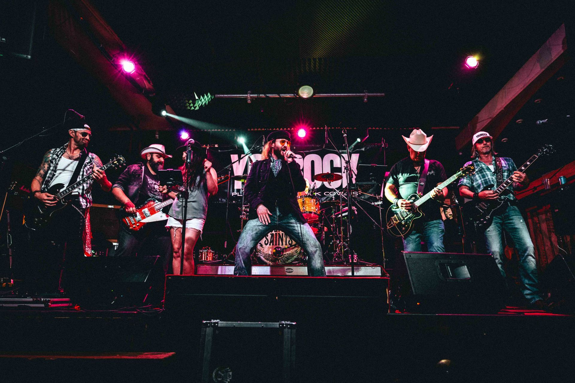 Zwei Männer spielen in einem Studio E-Gitarre; einer mit Bart, lächelnd, der andere mit Tätowierung.