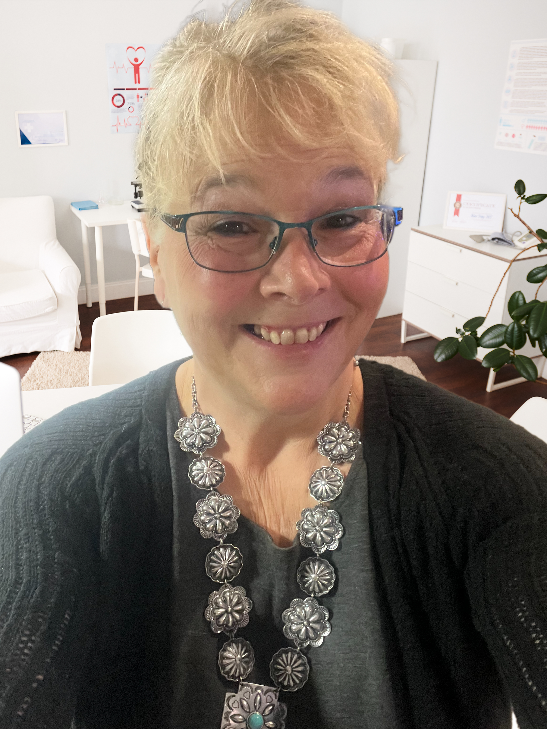 A woman is writing on a clipboard while a man sits in the background.