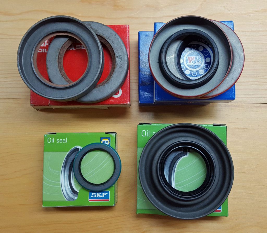 Four boxes, each with a different circular automotive seal, varying in size and color.