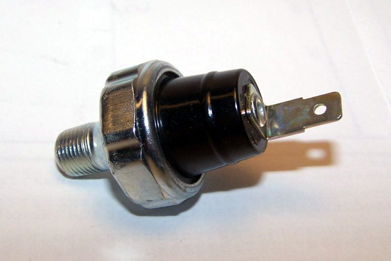 Oil pressure sensor with a silver body, black plastic housing, and a metal terminal.