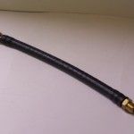 Black hose with brass fittings on a white background.