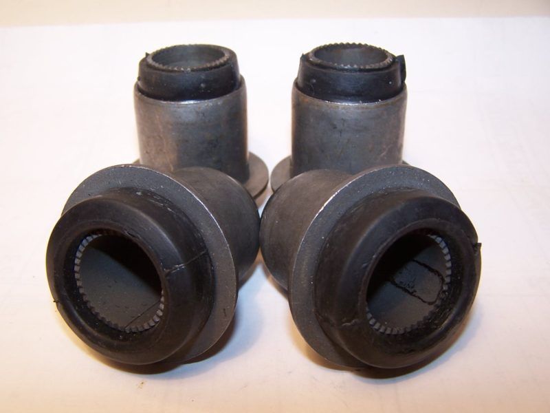 Four cylindrical bushings with rubber inserts. They appear metallic gray with black rubber.