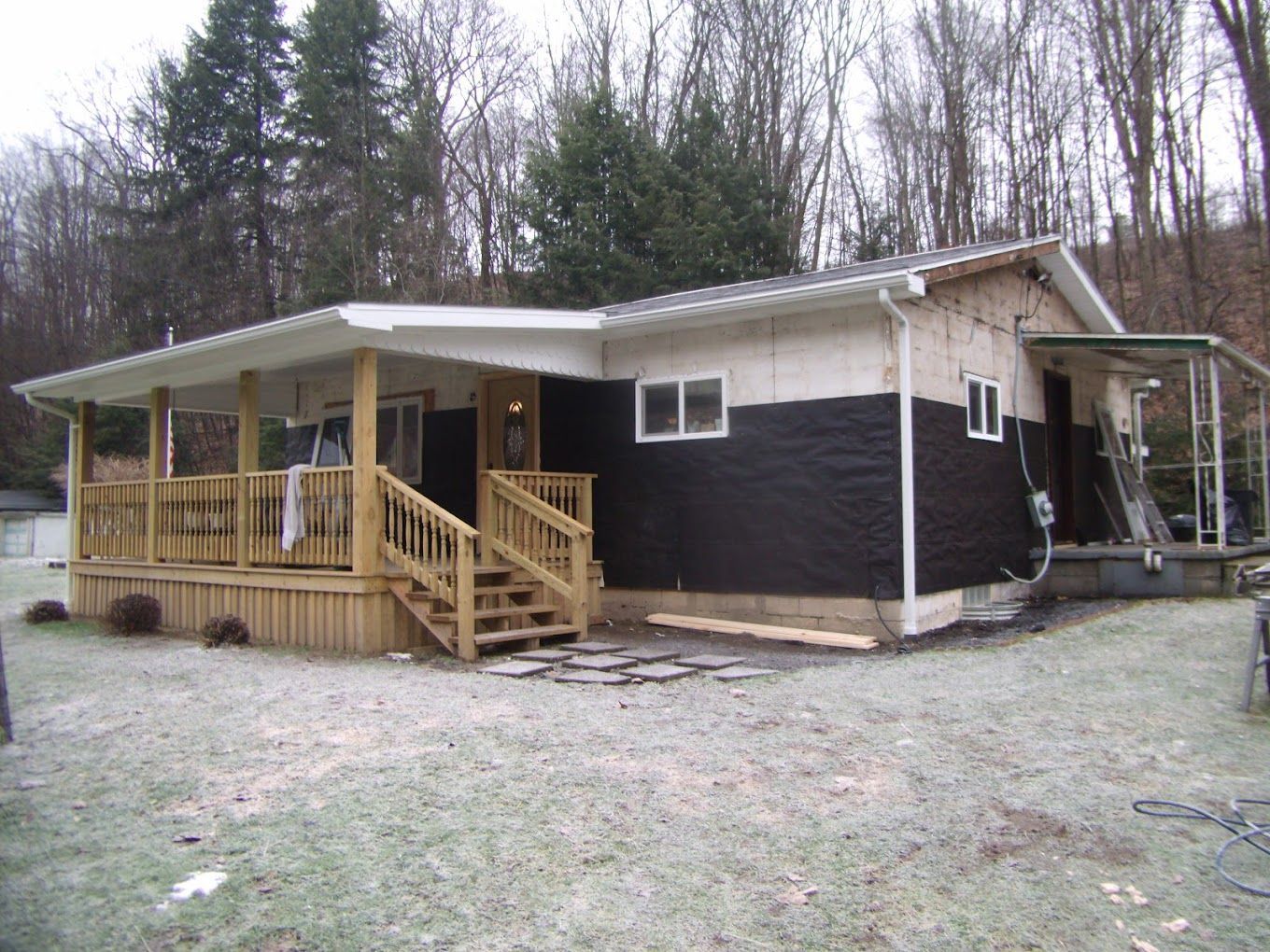 A black and white house with a porch and stairs