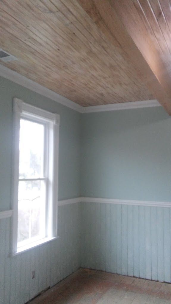 A room with a wooden ceiling and a window.
