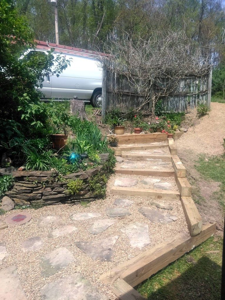 A white van is parked in the backyard next to a wooden staircase.