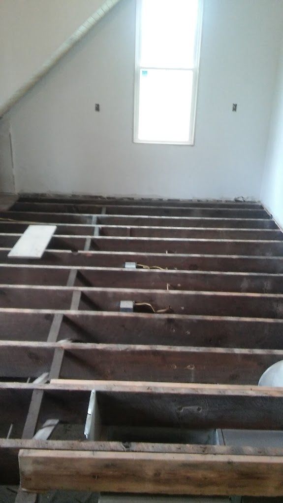 A room with a wooden floor and a window.