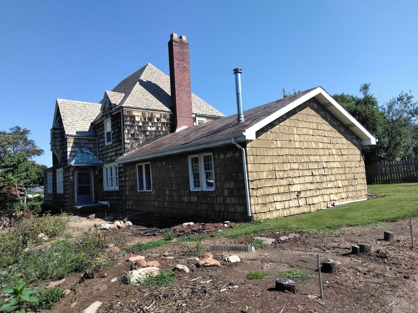 A large house with a chimney and a lot of windows