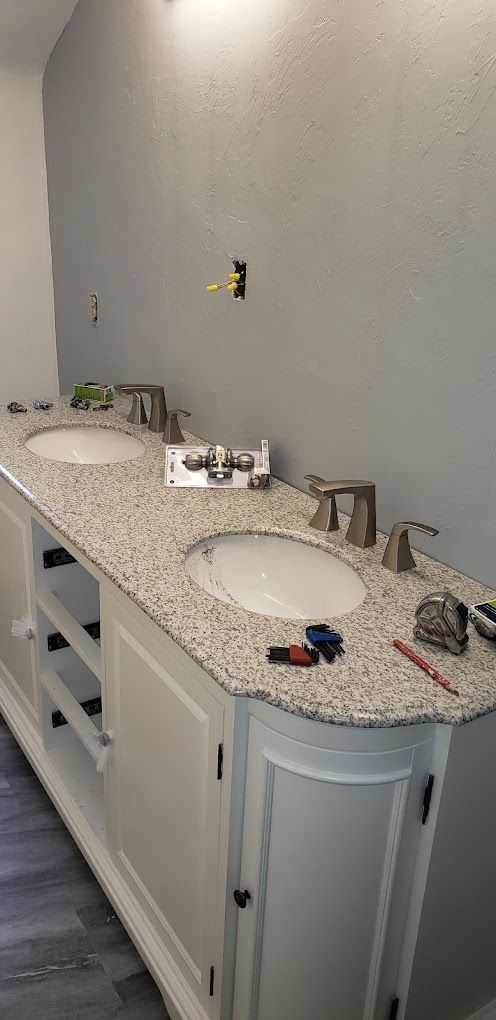 A bathroom with two sinks and a granite counter top.