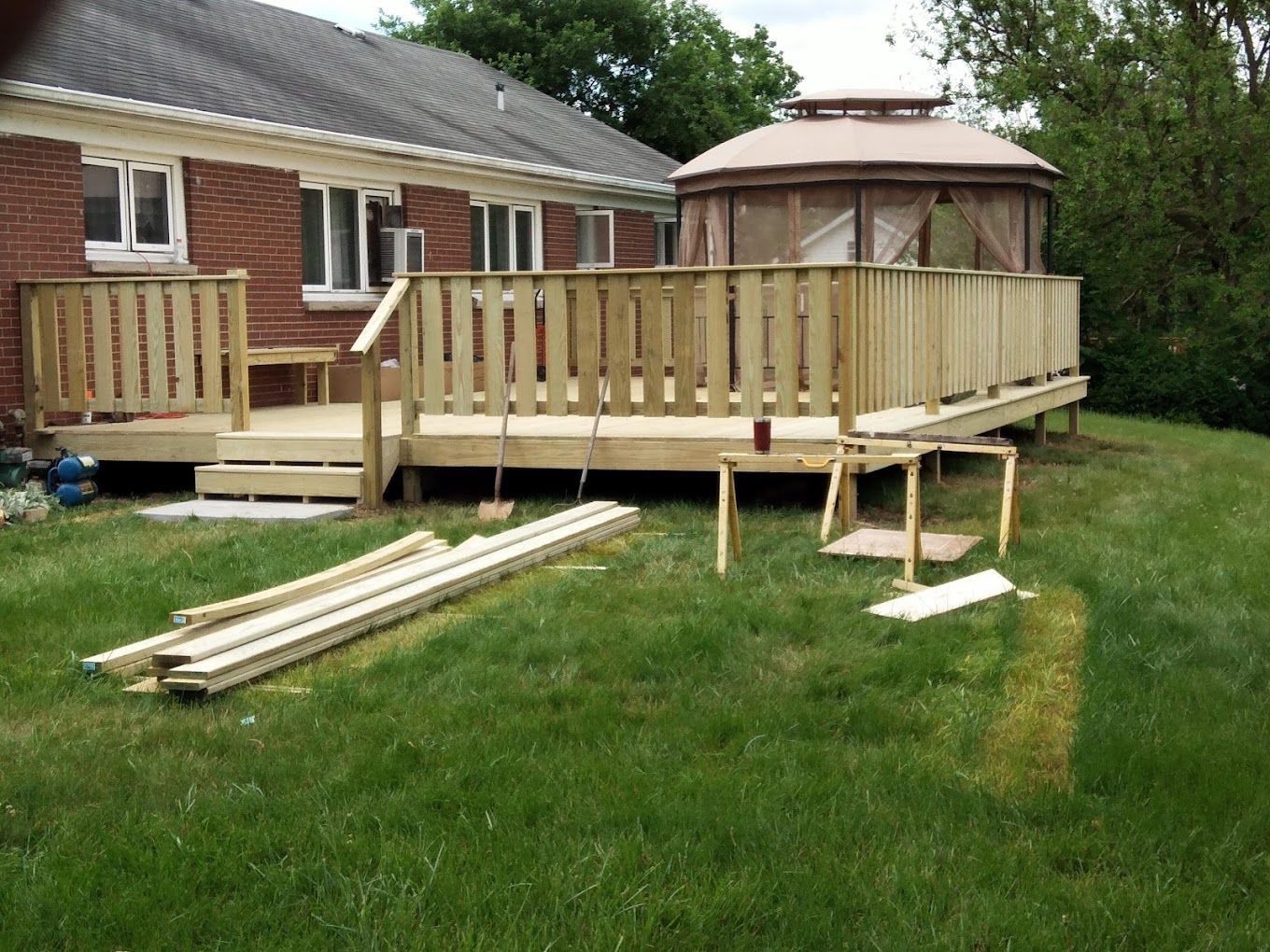 A wooden deck with a gazebo in the background