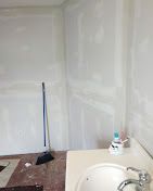 A bathroom with a sink and a broom on the floor.