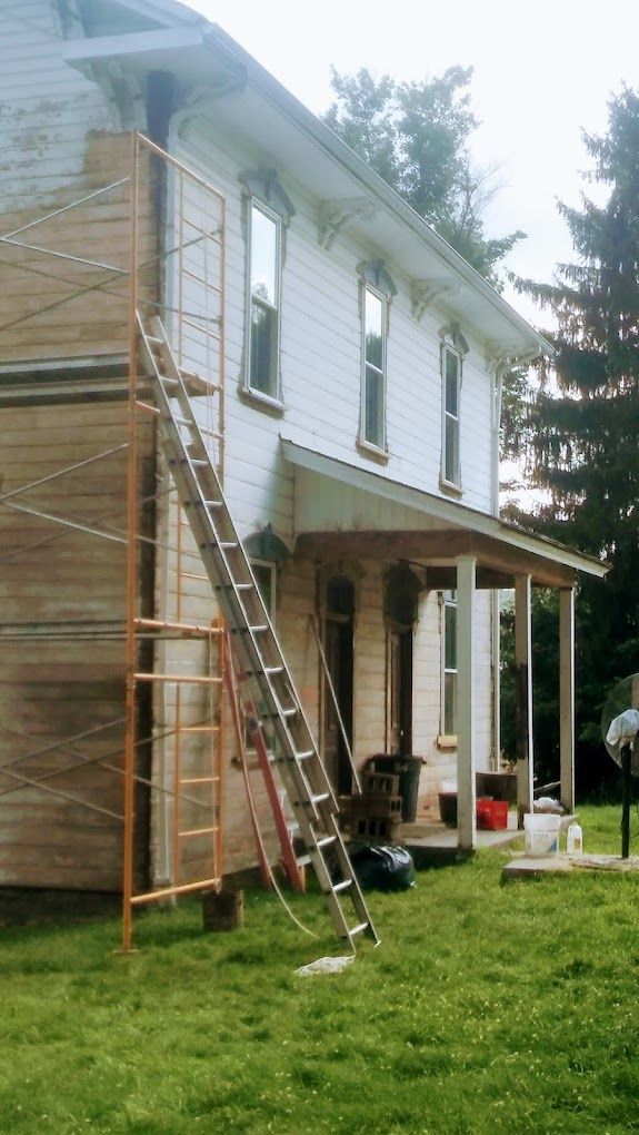 A white house with a ladder on the side of it