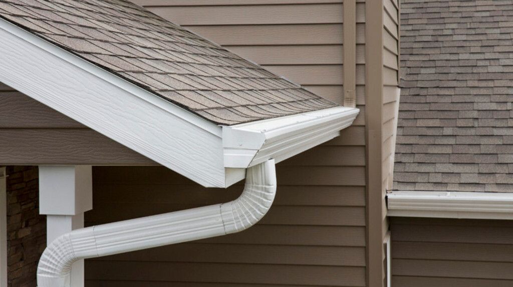 A close up of a gutter on the side of a house