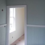 An empty room with light blue walls and a window