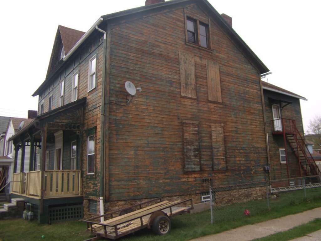A large wooden house with a trailer parked in front of it