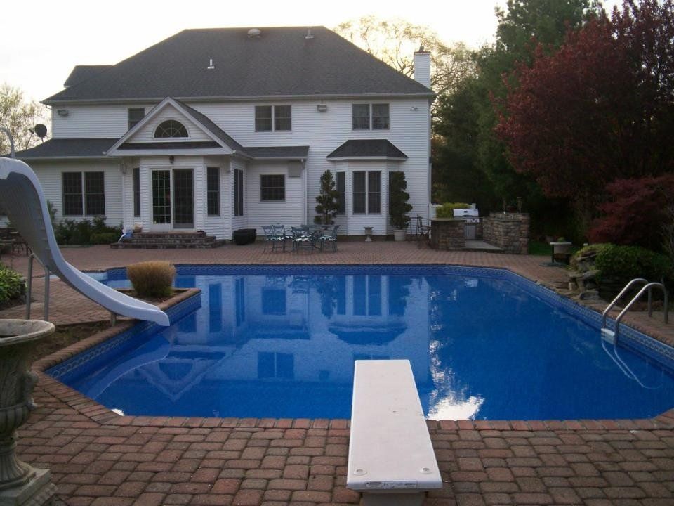 a large white house with a large swimming pool in front of it