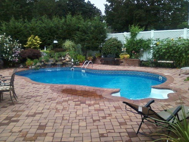 a large swimming pool is surrounded by bricks and chairs