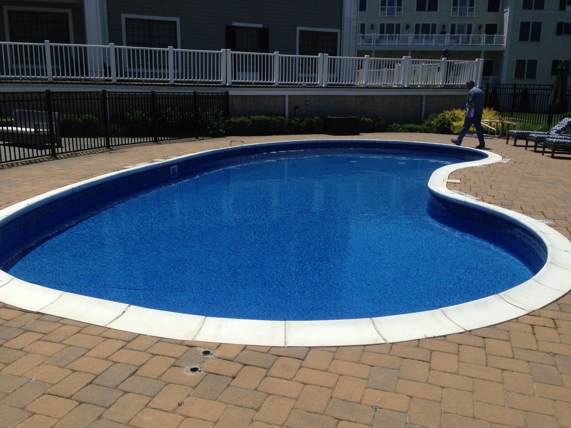 a large swimming pool with a white fence around it