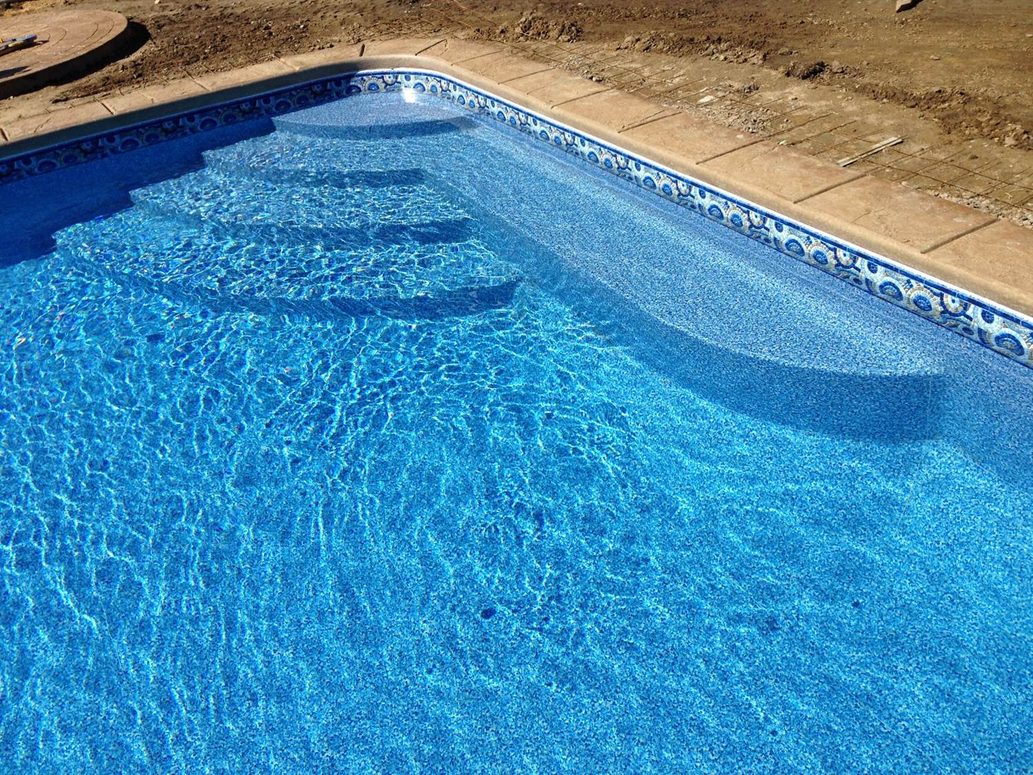 a swimming pool with blue tiles and steps