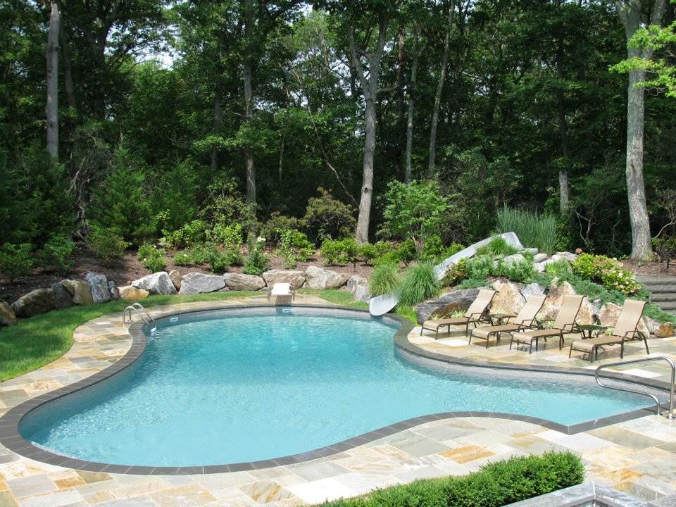 a large swimming pool surrounded by chairs and trees