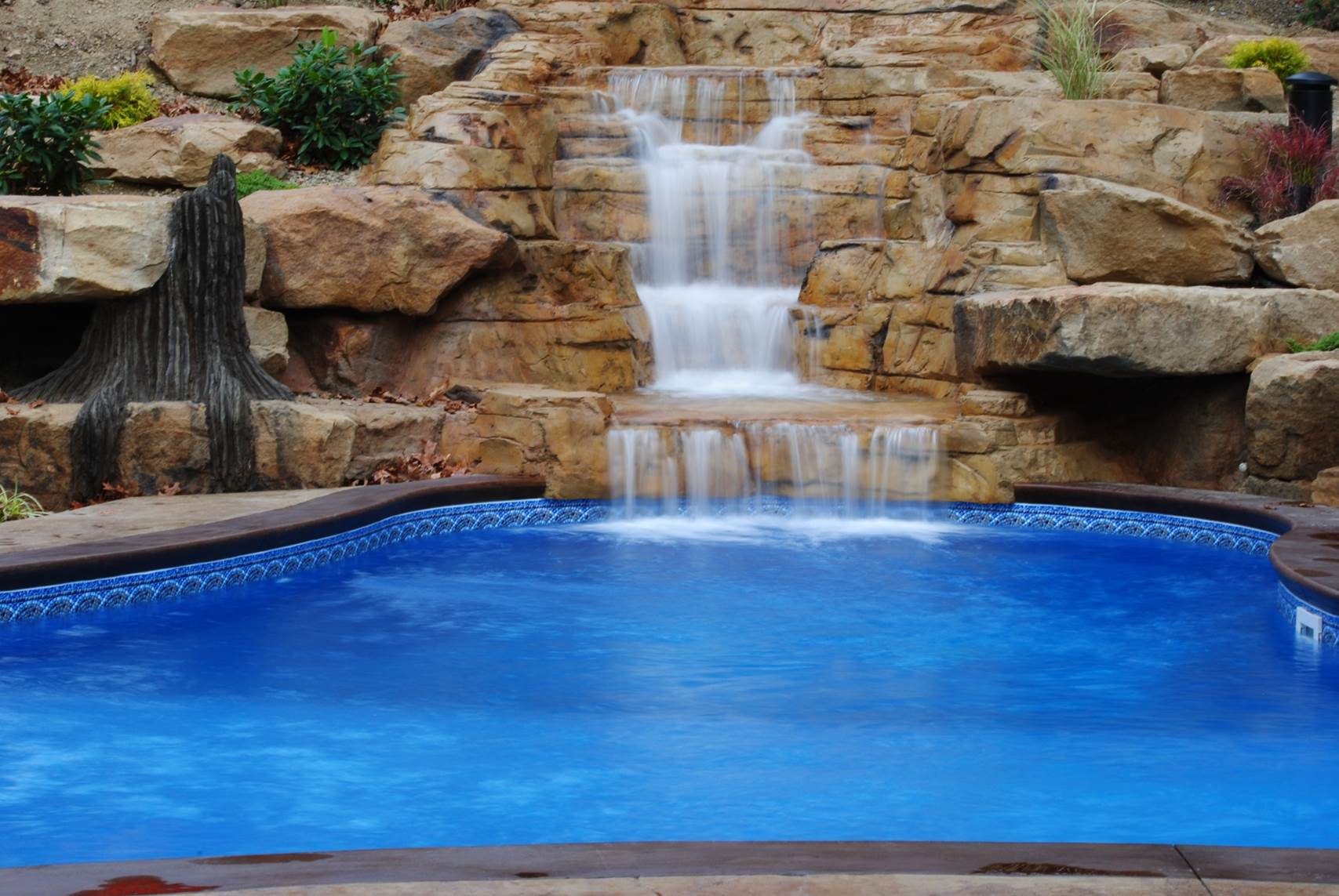 a pool with a waterfall in the background
