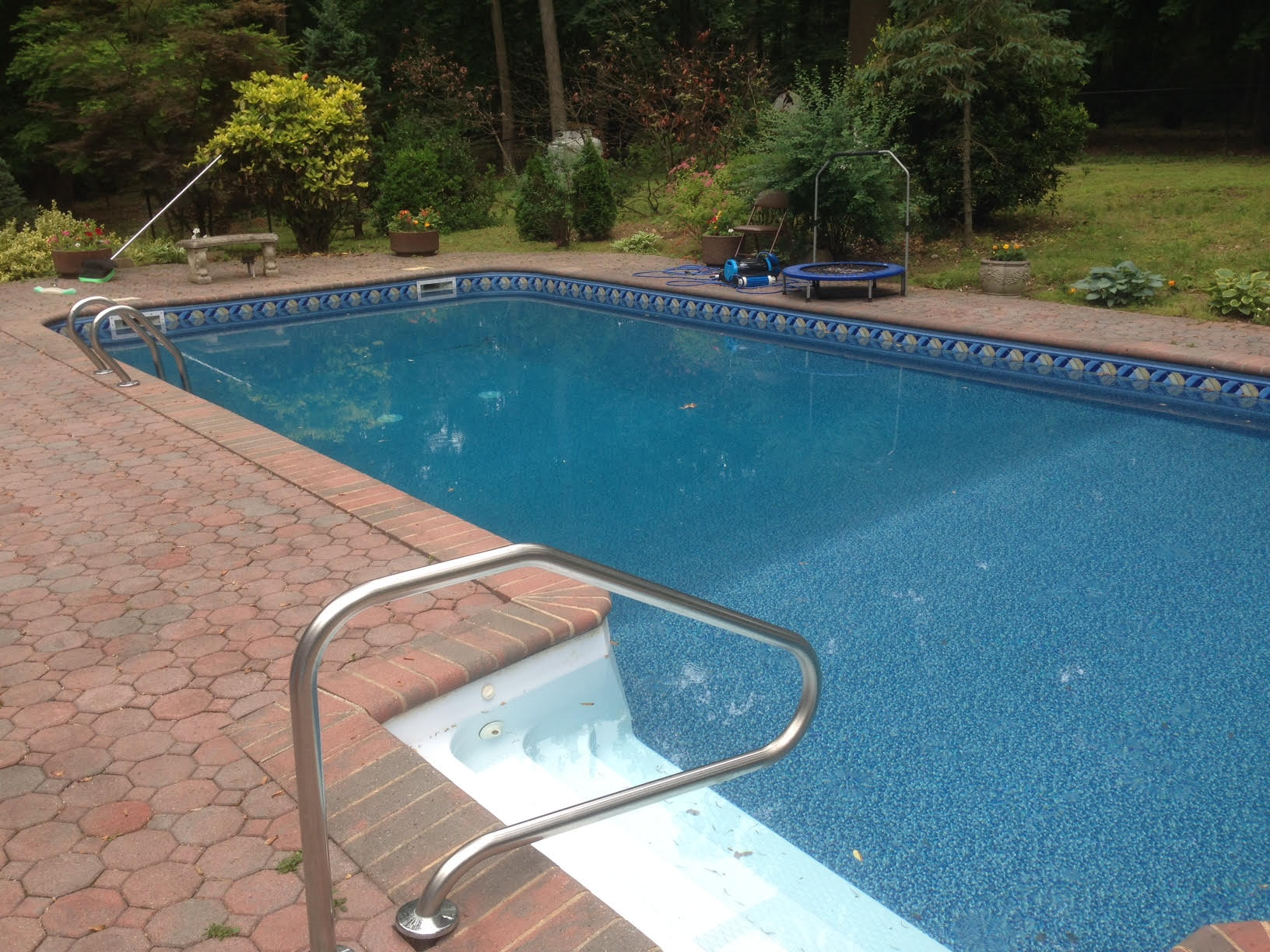 a large swimming pool with a trampoline in the background