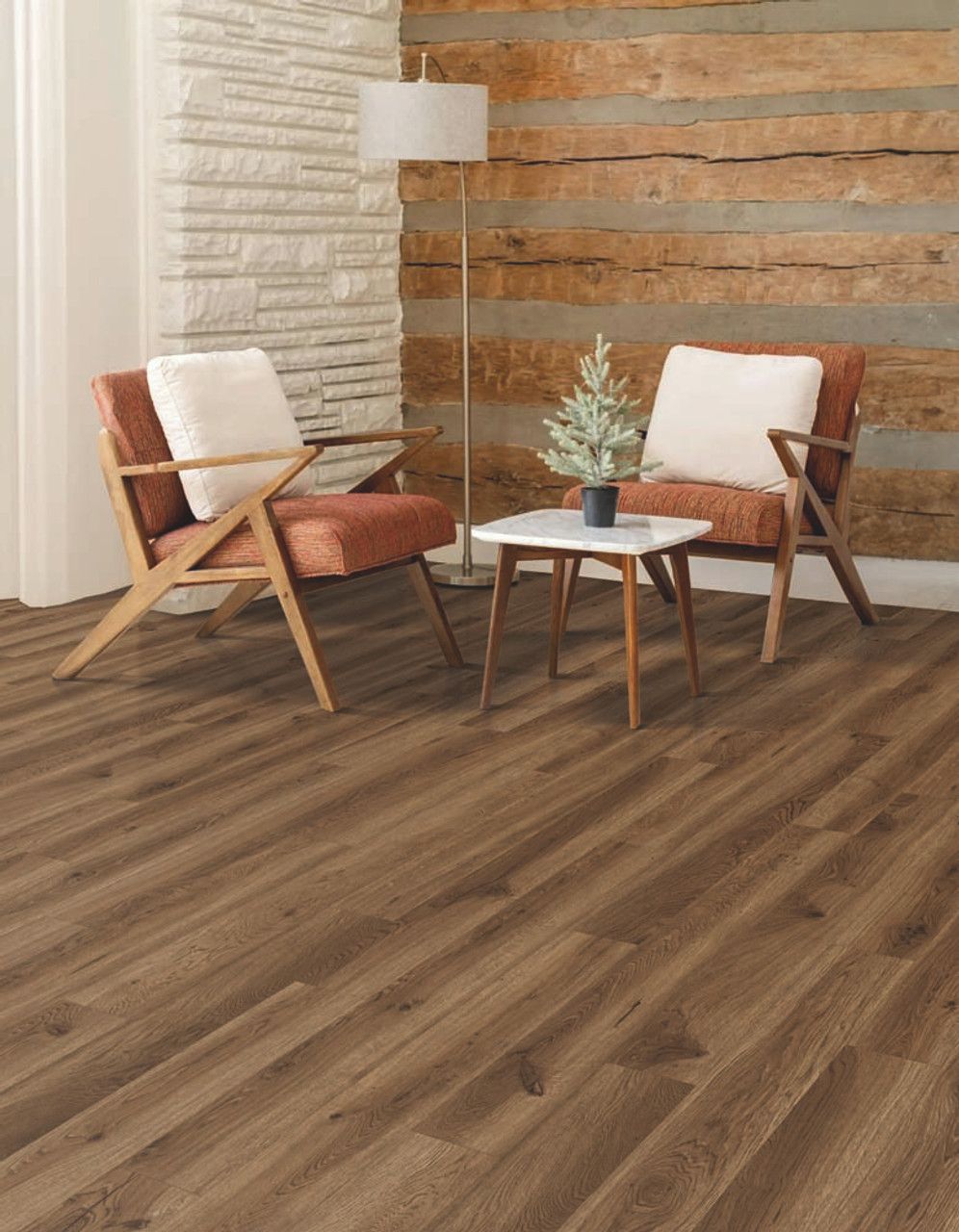 Living room with wood flooring, chairs, table, and a decorative wall.