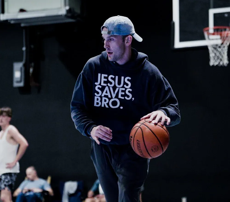 A man dribbling a basketball, wearing a 