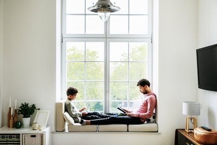 man and son sitting in window lounge area