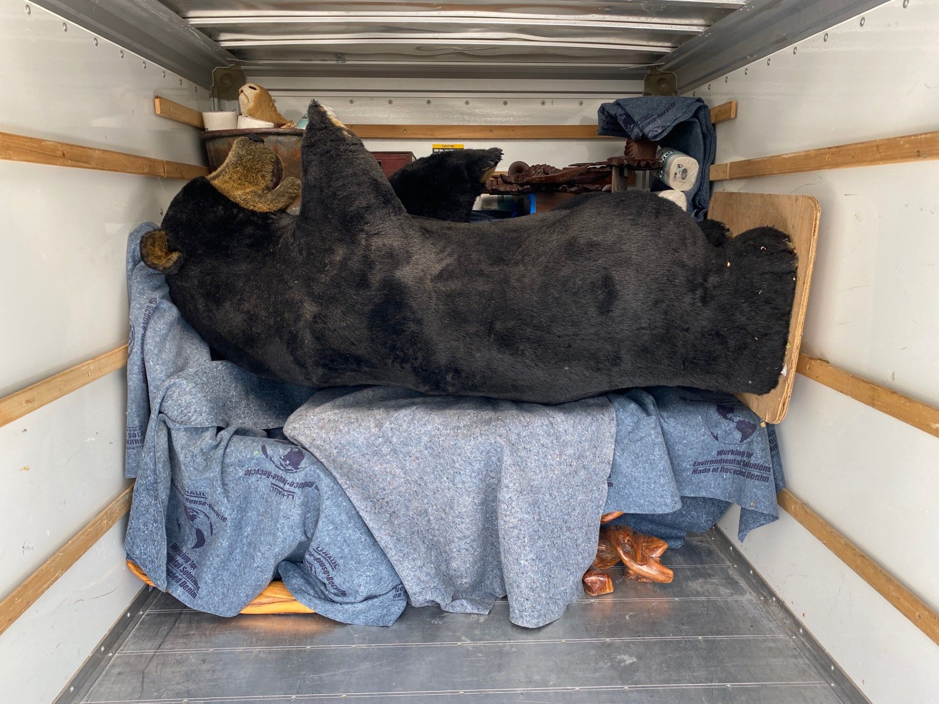 Three people loading a moving truck in a city. Two women and a man are opening the truck and handling the contents. Three people loading a moving truck in a city. Two women and a man are opening the truck and handling the contents.