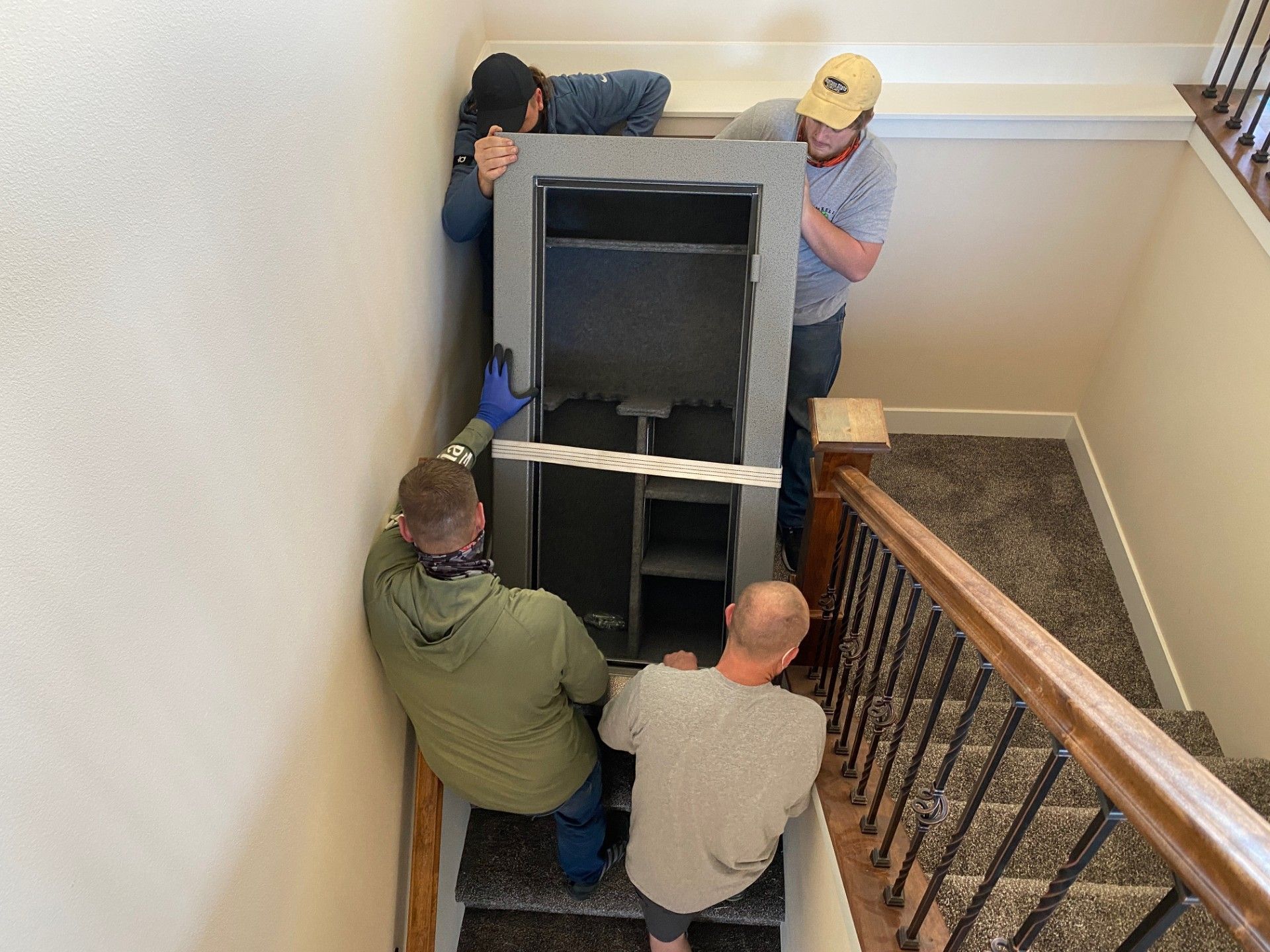 Two movers packing books and a tablet into a cardboard box in a room. Two movers packing books and a tablet into a cardboard box in a room.