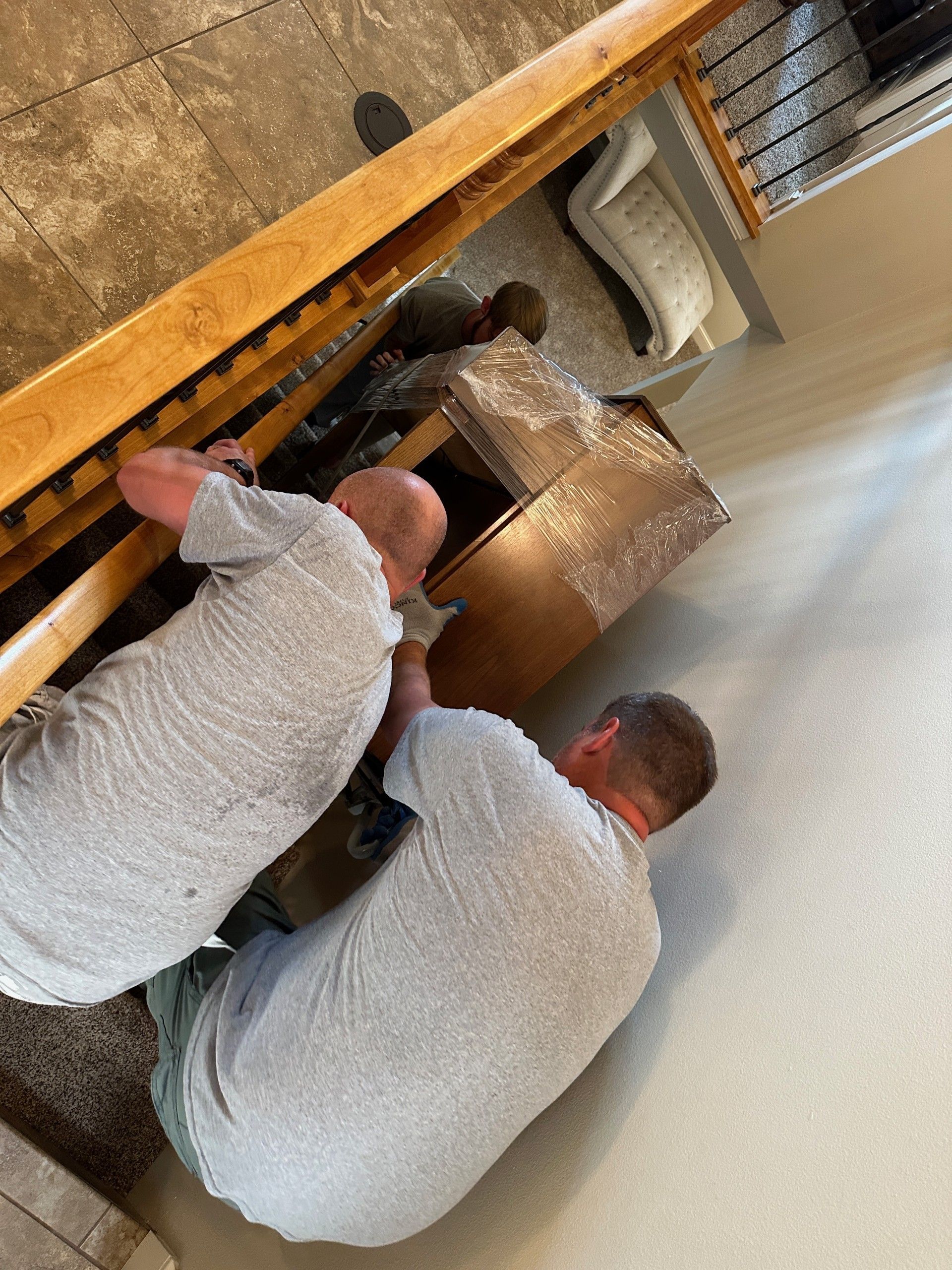 Office being moved; boxes stacked, chair covered in plastic, desks visible. Office being moved; boxes stacked, chair covered in plastic, desks visible.
