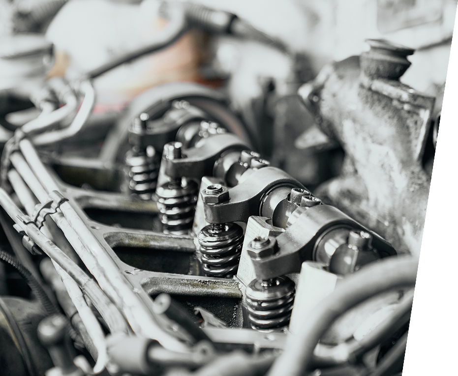 Primer plano de los balancines, resortes y componentes asociados de un motor, con un fondo borroso parcialmente visible.
