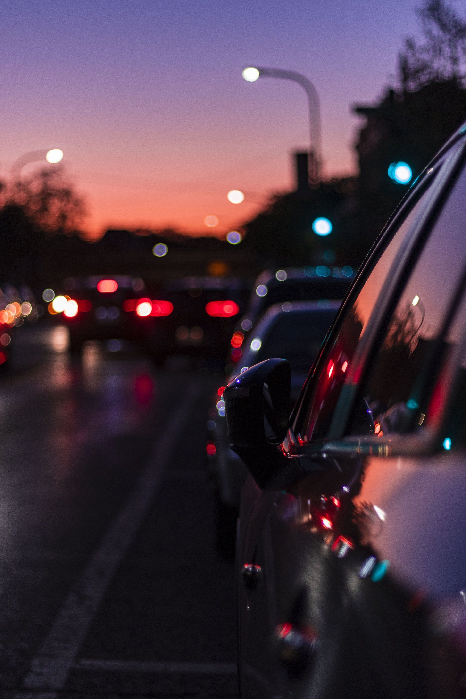 A car is parked on the side of the road at night.