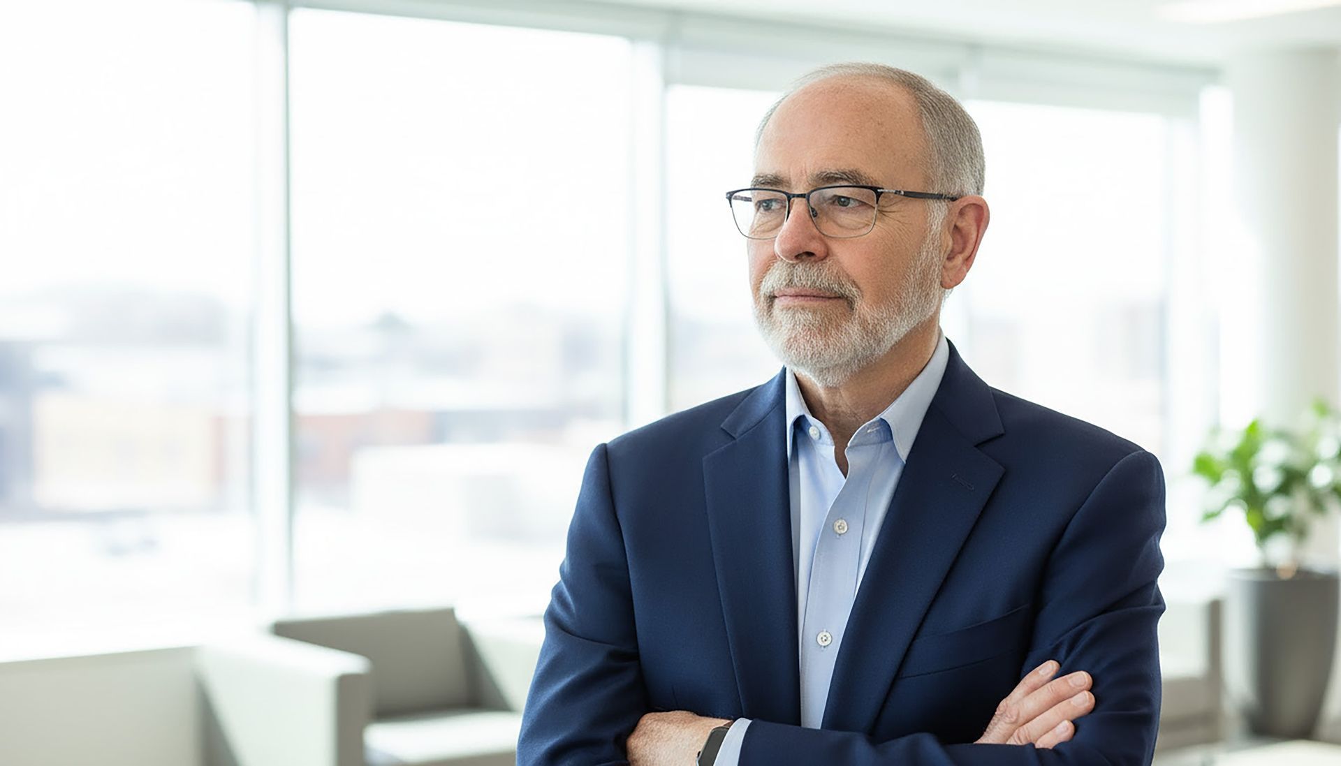 A man in a suit and tie is standing in front of a bookshelf.