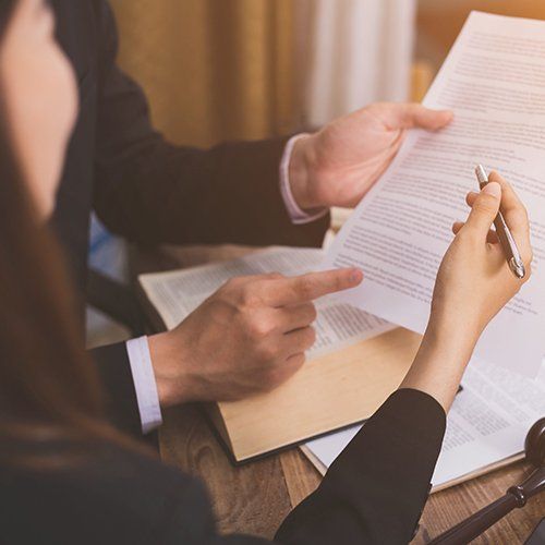 A man and a woman are sitting at a table looking at a piece of paper.