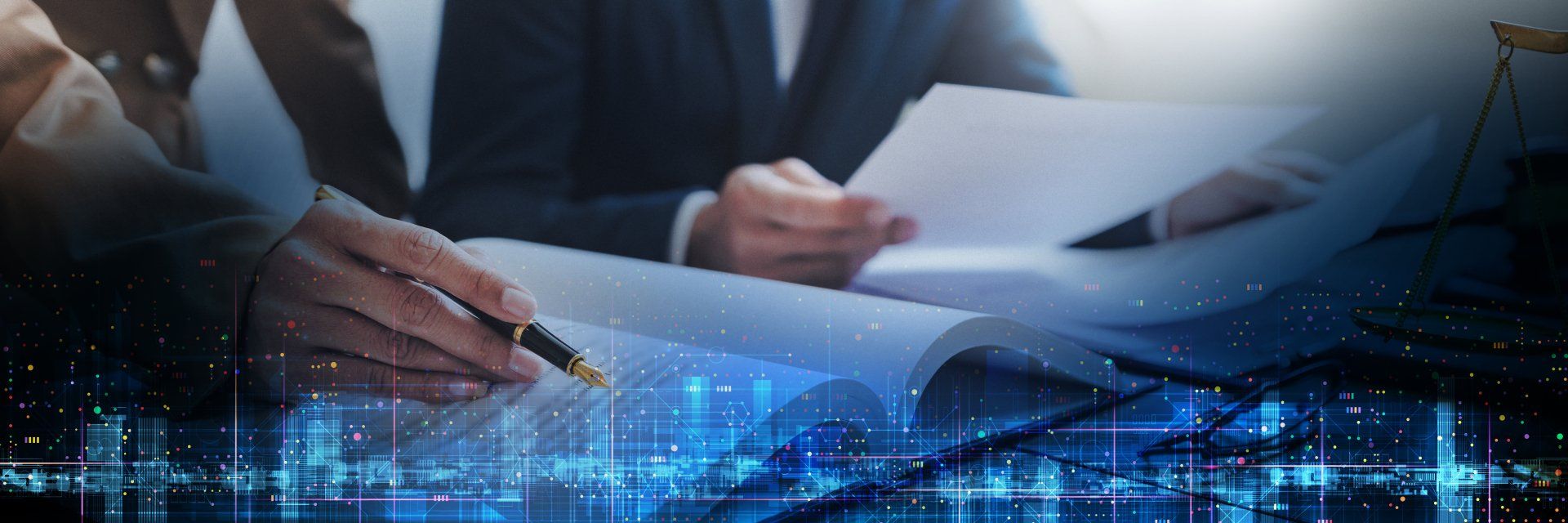 A man in a suit is signing a document with a pen.