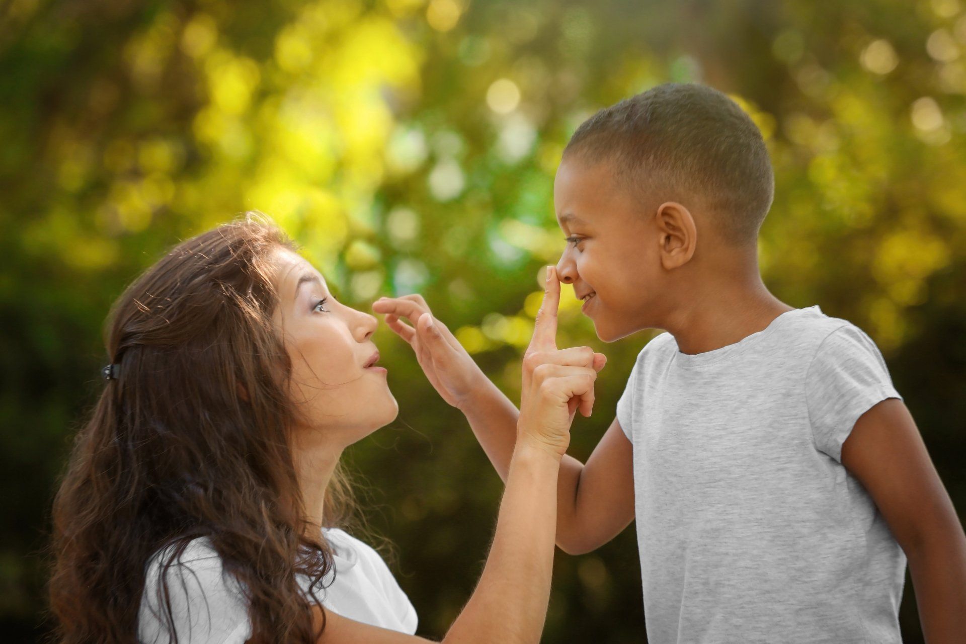 A mom and son are touching each others' noses.