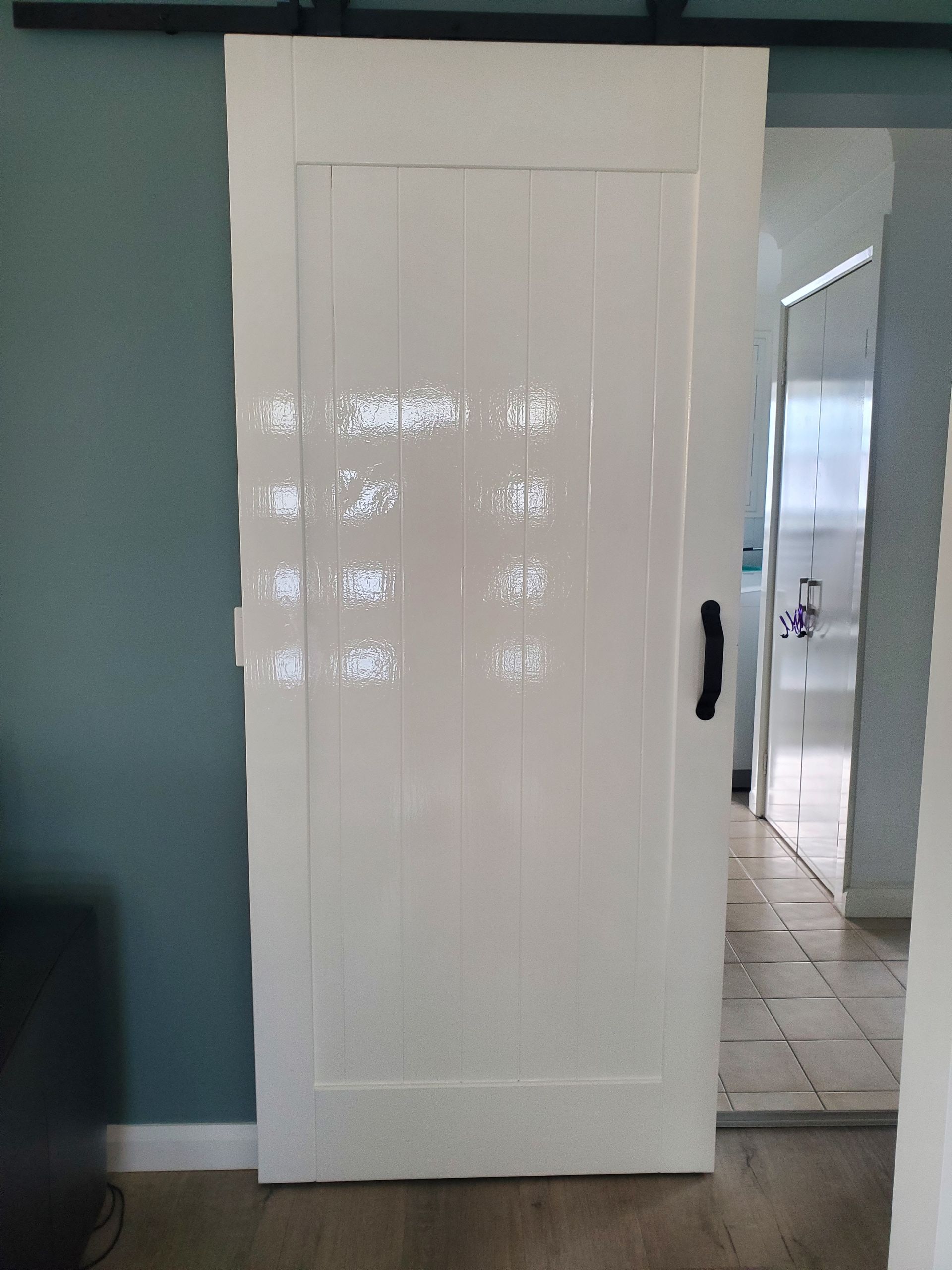 A white sliding barn door is open in a living room — JWP Painting & Property Services in Ettalong Beach, NSW