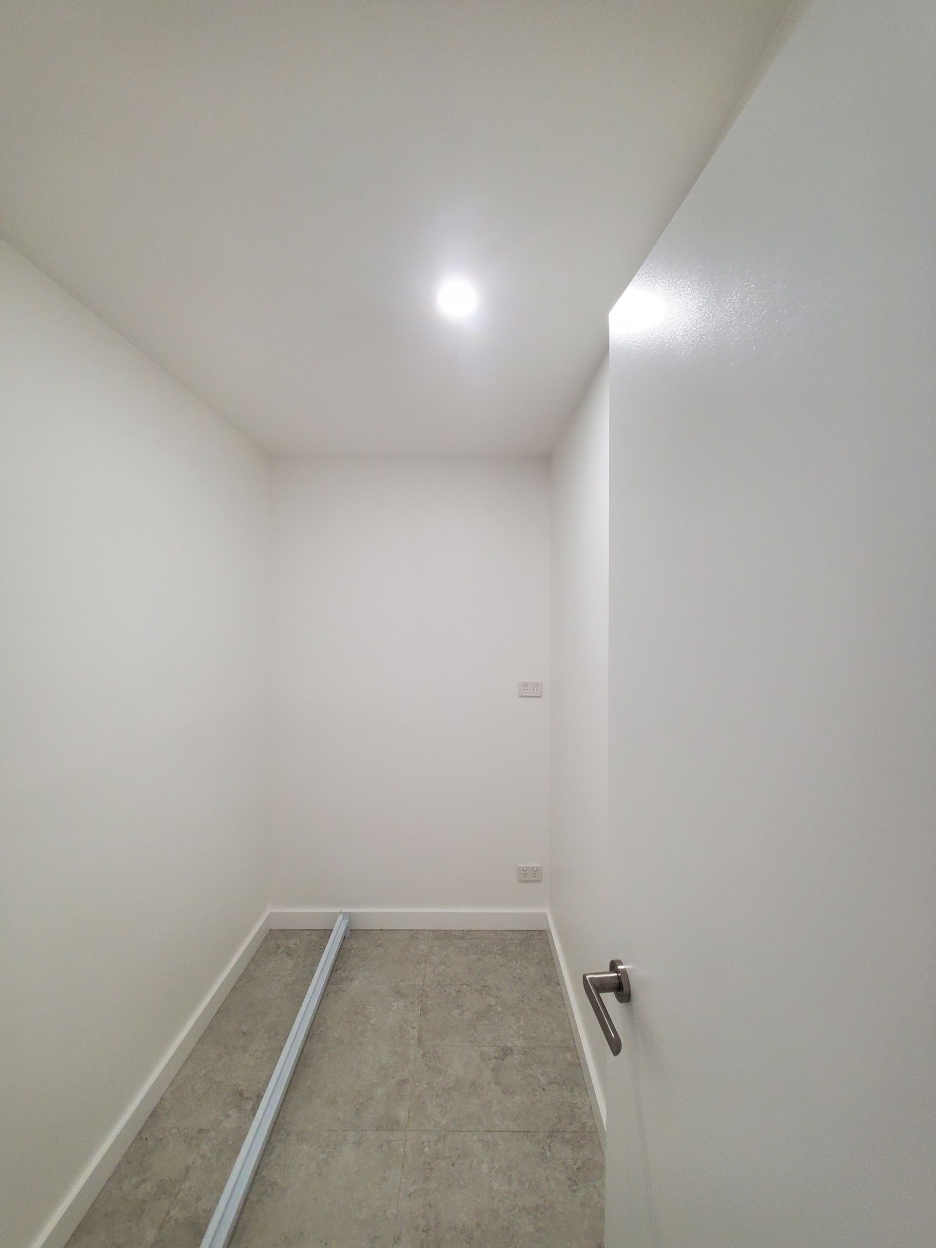 An empty room with white walls and a light on the ceiling — JWP Painting & Property Services in Ettalong Beach, NSW