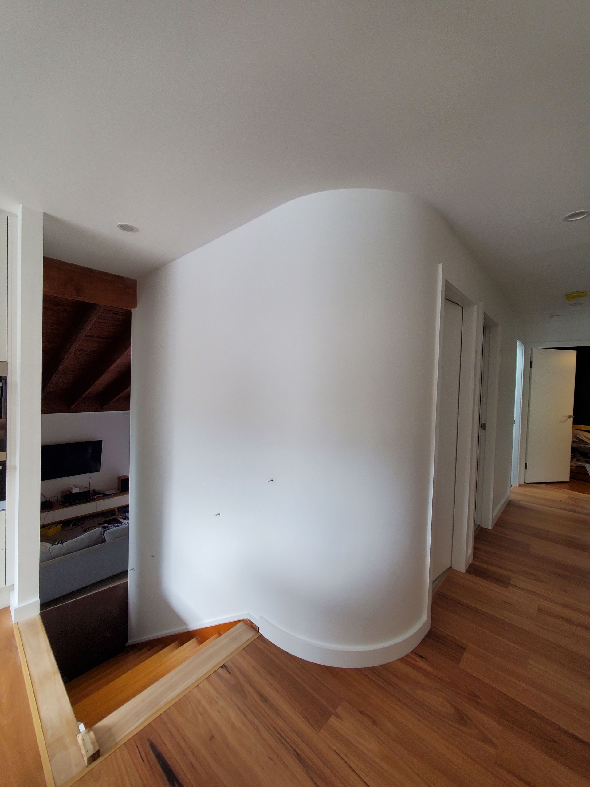 A hallway with a curved wall and wooden floors — JWP Painting & Property Services in Ettalong Beach, NSW