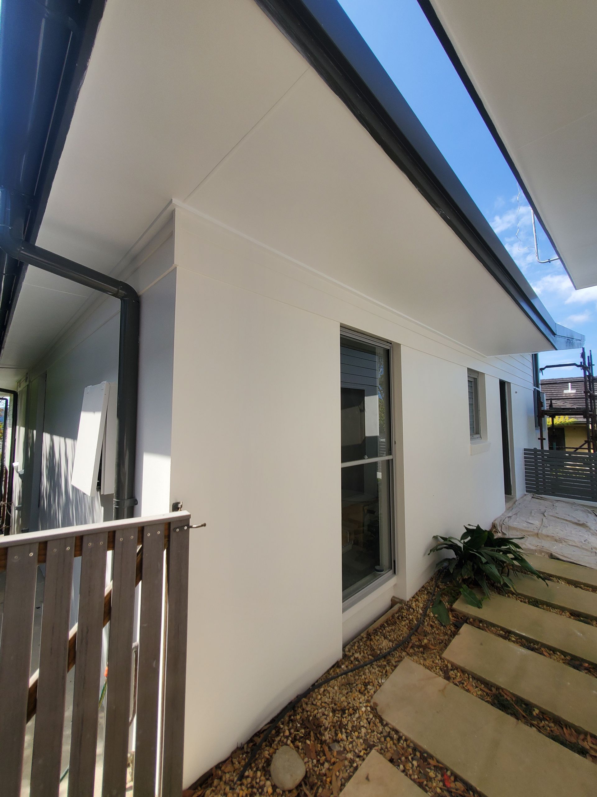 A white house with a wooden fence in front of it — JWP Painting & Property Services in Ettalong Beach, NSW