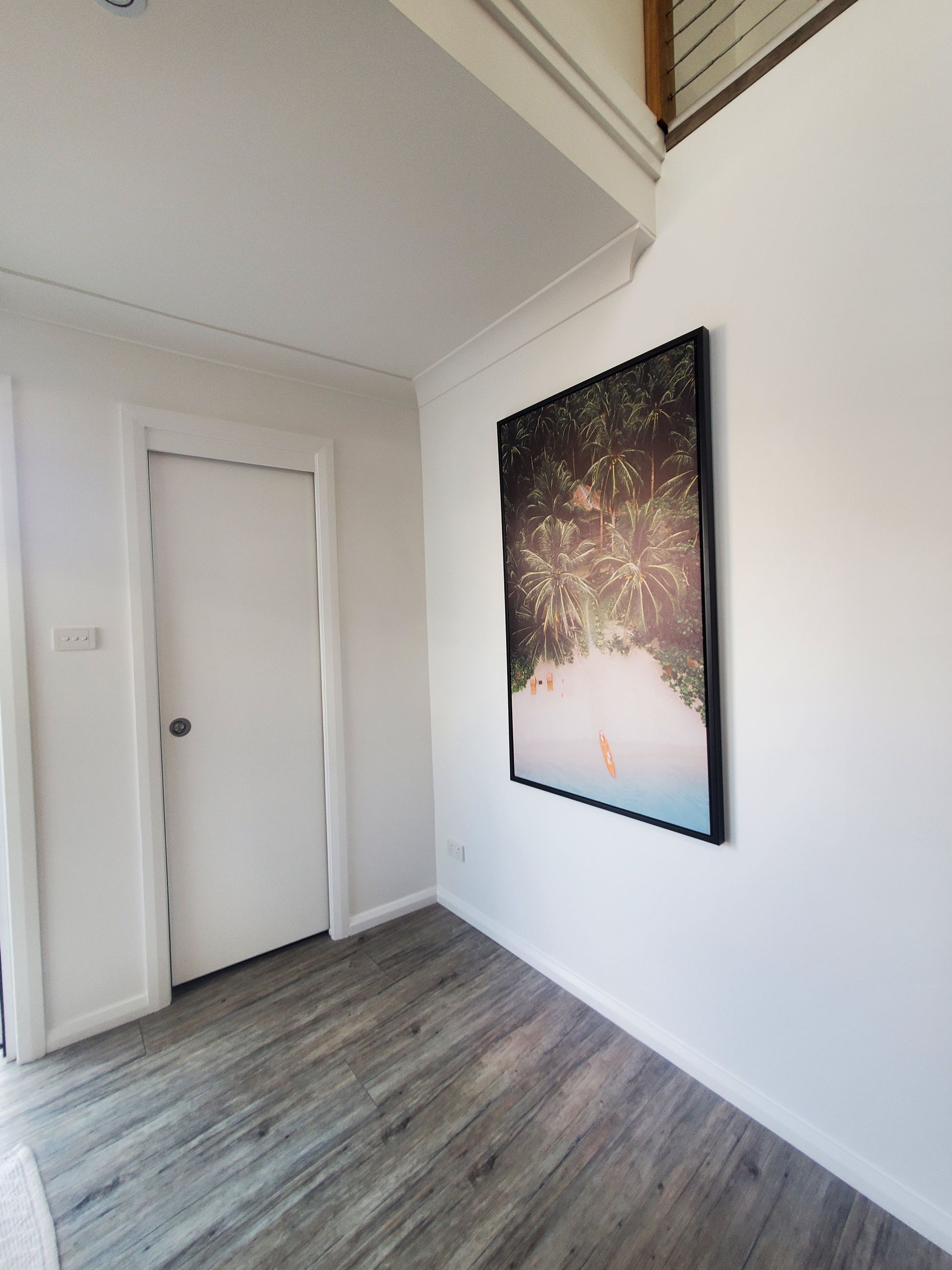 A hallway with a painting on the wall and a door — JWP Painting & Property Services in Ettalong Beach, NSW
