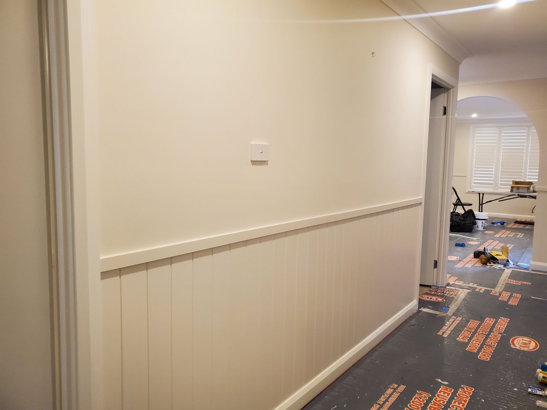 A hallway with white walls and trim is being painted — JWP Painting & Property Services in Ettalong Beach, NSW