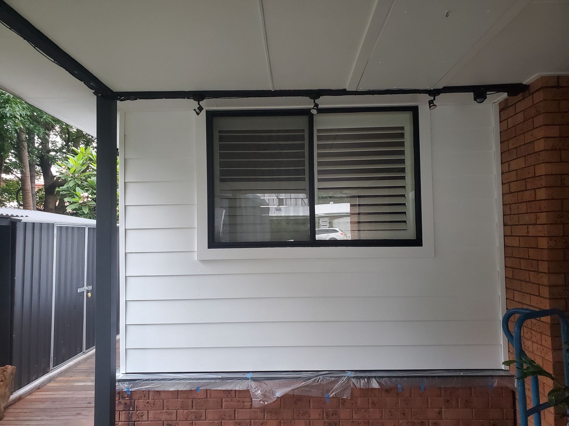 A white house with a window on the side of it — JWP Painting & Property Services in Ettalong Beach, NSW