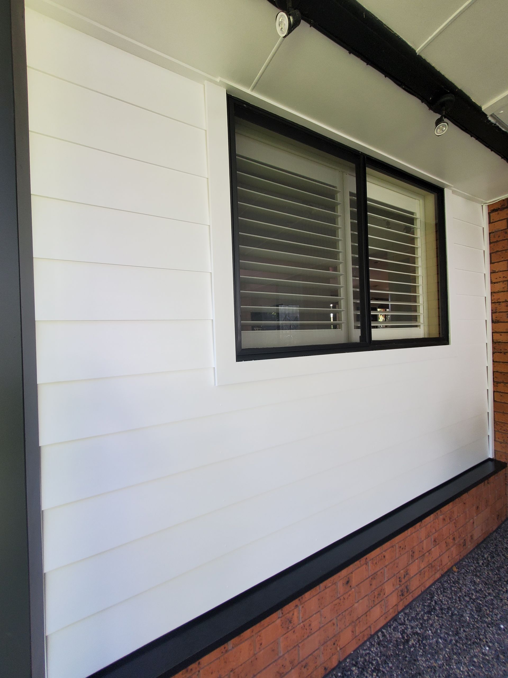 A white house with a window and shutters on it — JWP Painting & Property Services in Ettalong Beach, NSW
