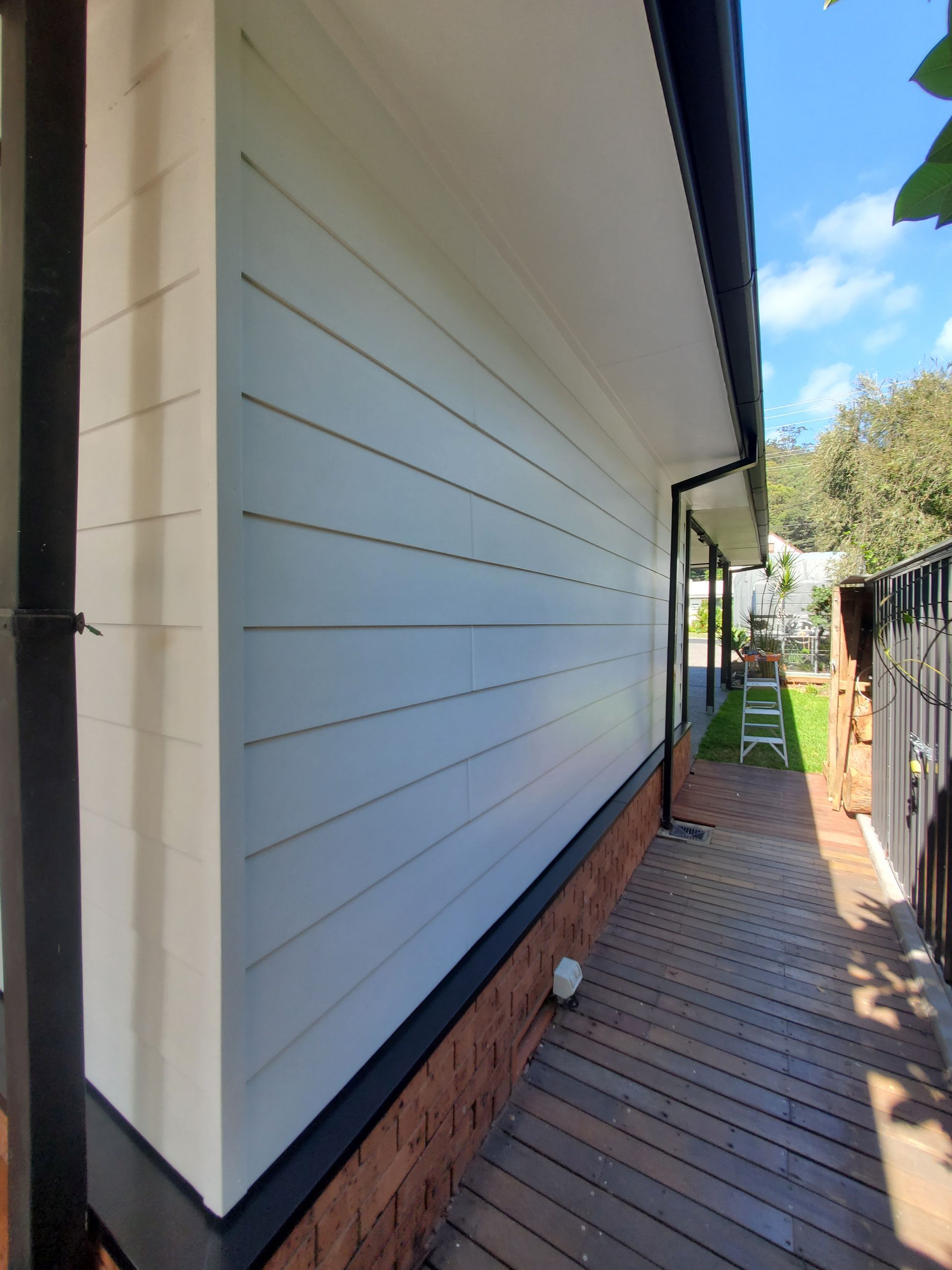 The side of a house with white siding and black trim — JWP Painting & Property Services in Ettalong Beach, NSW