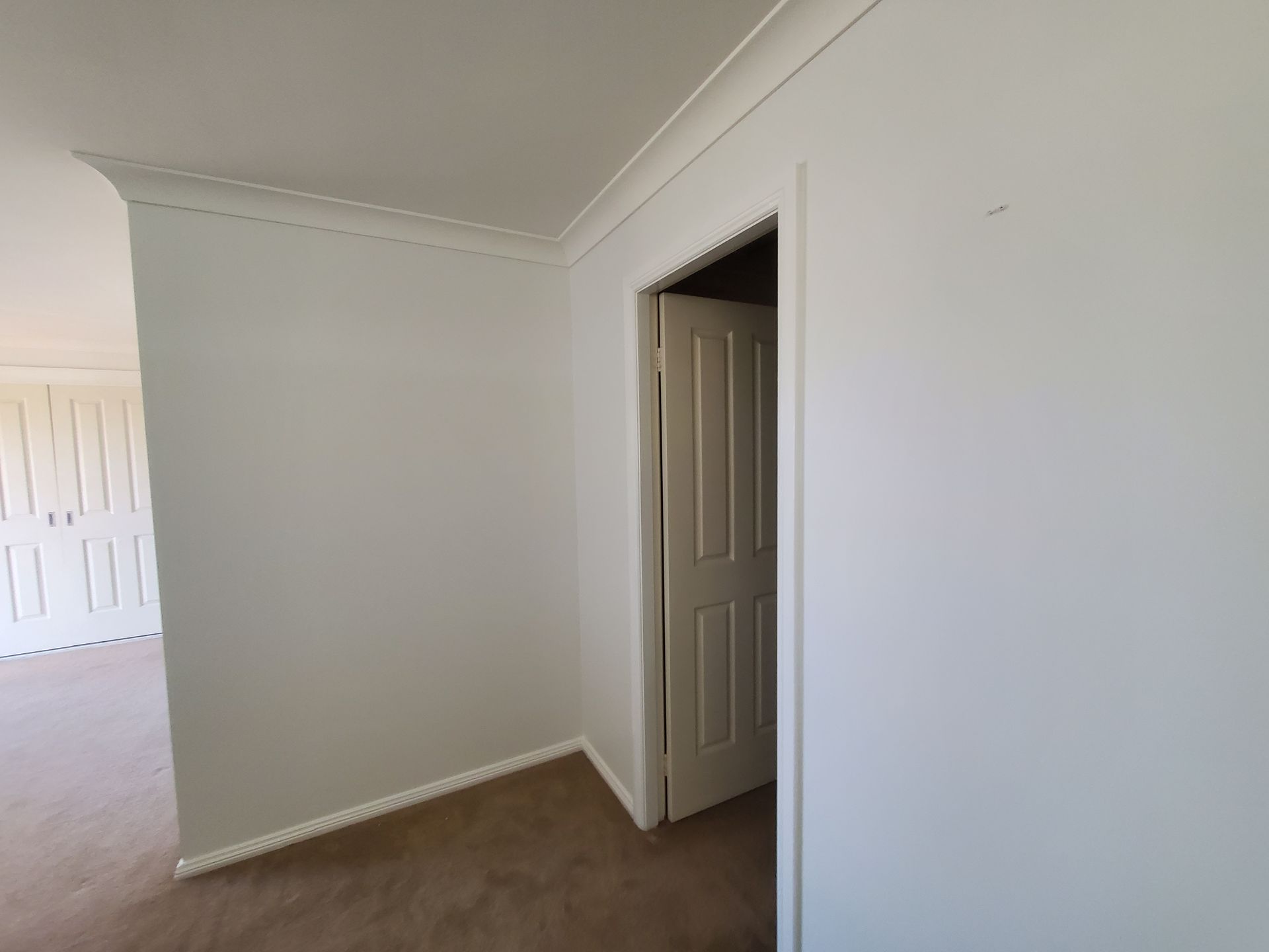 An empty room with a door leading to a closet — JWP Painting & Property Services in Ettalong Beach, NSW